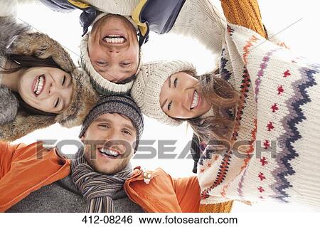 Stock Photograph - Low angle portrait of happy friends in huddle. Fotosearch