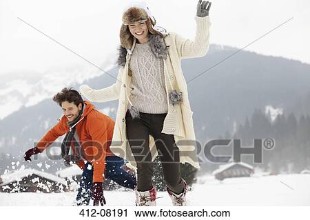 Playful couple running in snowy field View Large Photo Image Stock Image - Playful couple running in snowy field. Fotosearch