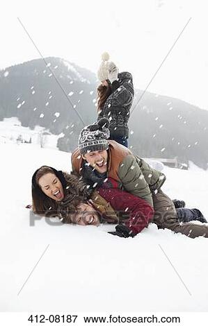 Playful friends enjoying snowball fight in field View Large Photo Image Stock Photo - Playful friends enjoying snowball fight in field. Fotosearch