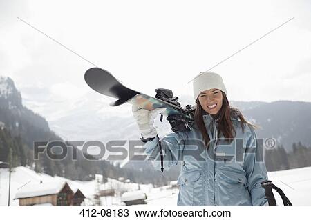 Portrait of enthusiastic woman carrying skis in snowy field View Large Photo Image Stock Image - Portrait of enthusiastic woman carrying skis in snowy field. Fotosearch