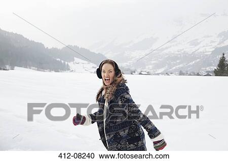 Portrait of enthusiastic woman running in snowy field View Large Photo Image Stock Image - Portrait of enthusiastic woman running in snowy field. Fotosearch