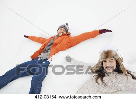 Portrait of happy couple making snow angels View Large Photo Image Picture - Portrait of happy couple making snow angels. Fotosearch