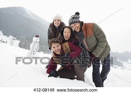 Portrait of happy friends in snowy field with snowman View Large Photo Image Stock Photo - Portrait of happy friends in snowy field with snowman. Fotosearch