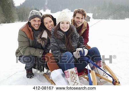 Portrait of happy friends on sled in snowy field View Large Photo Image Stock Photo - Portrait of happy friends on sled in snowy field. Fotosearch