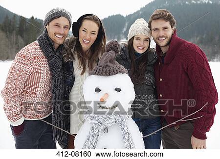 Portrait of happy friends with snowman View Large Photo Image Stock Image - Portrait of happy friends with snowman. Fotosearch