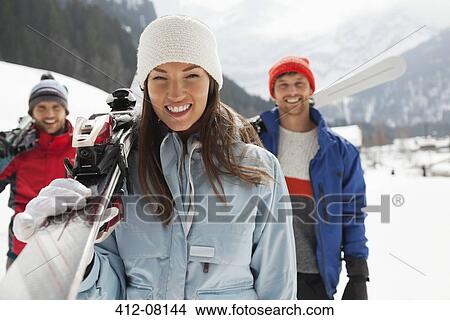 Portrait of smiling friends carrying skis View Large Photo Image Picture - Portrait of smiling friends carrying skis. Fotosearch