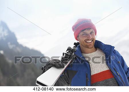 Portrait of smiling man holding skis View Large Photo Image Stock Image - Portrait of smiling man holding skis. Fotosearch