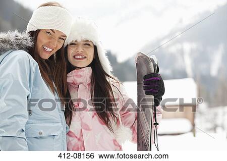 Stock Photograph - Portrait of smiling women with skis. Fotosearch