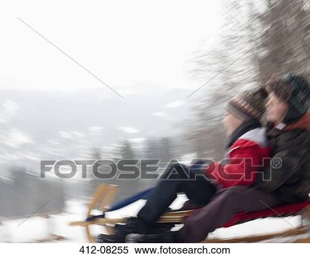 Stock Photography - Blurred motion view of boys sledding in snow. Fotosearch