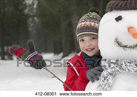 Close up of smiling boy behind snowman View Large Photo Image Stock Image - Close up of smiling boy behind snowman. Fotosearch