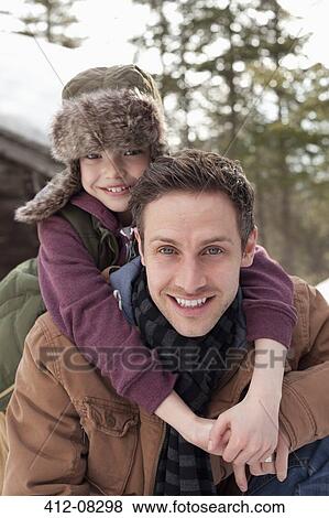 Stock Photo - Close up portrait of happy father piggybacking son. Fotosearch