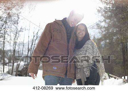 Stock Photo - Happy couple hugging in snowy woods. Fotosearch
