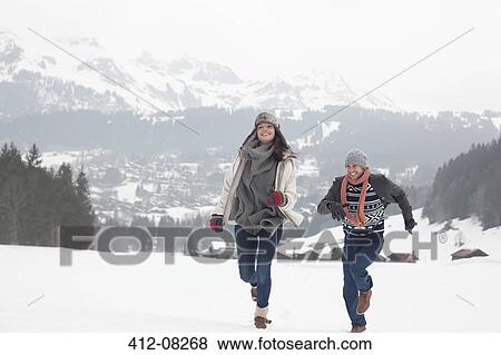 Stock Photo - Happy couple running in snowy field. Fotosearch