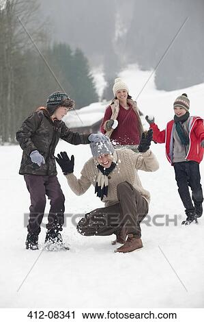 Happy family enjoying snowball fight in field View Large Photo Image Stock Image - Happy family enjoying snowball fight in field. Fotosearch