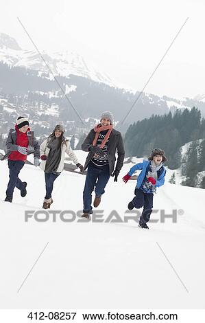Stock Photo - Happy family running in snowy field. Fotosearch