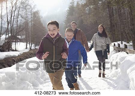 Happy family running in snowy lane View Large Photo Image Stock Image - Happy family running in snowy lane. Fotosearch