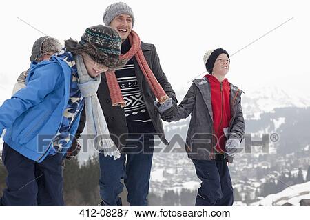 Stock Photo - Happy family walking in snow. Fotosearch