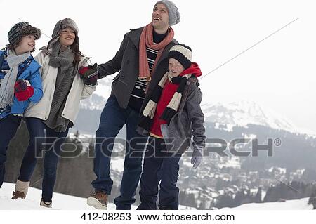 Happy family walking in snowy field View Large Photo Image Stock Image - Happy family walking in snowy field. Fotosearch