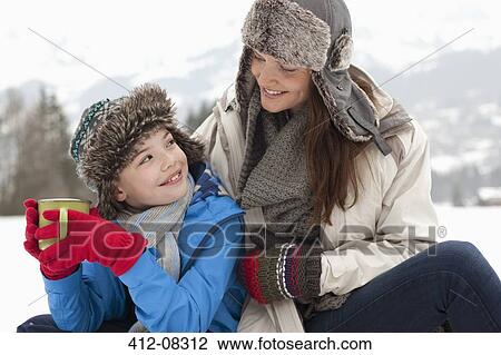 Happy mother and son drinking hot chocolate in snowy field View Large Photo Image Stock Image - Happy mother and son drinking hot chocolate in snowy field. Fotosearch