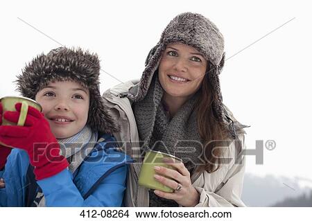 Happy mother and son in fur hats drinking hot chocolate View Large Photo Image Picture - Happy mother and son in fur hats drinking hot chocolate. Fotosearch