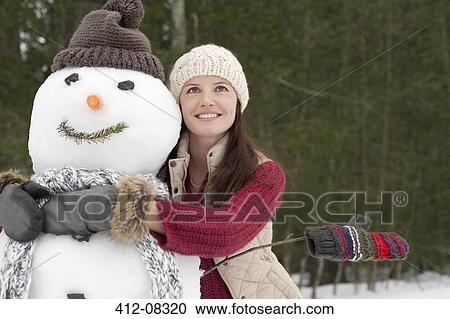Happy woman hugging snowman in woods View Large Photo Image Stock Image - Happy woman hugging snowman in woods. Fotosearch