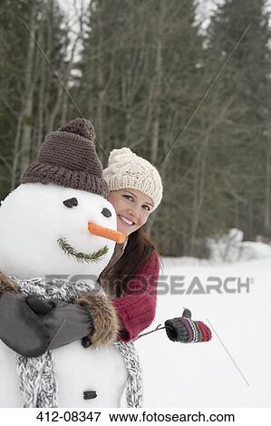 Happy woman hugging snowman in woods View Large Photo Image Stock Photo - Happy woman hugging snowman in woods. Fotosearch