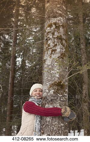 Happy woman hugging tree trunk in woods View Large Photo Image Stock Photography - Happy woman hugging tree trunk in woods. Fotosearch