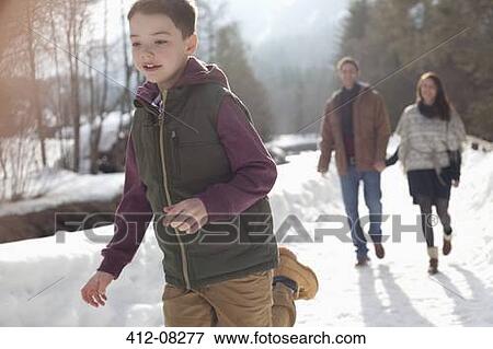 Parents watching boy run in snowy lane View Large Photo Image Stock Photo - Parents watching boy run in snowy lane. Fotosearch