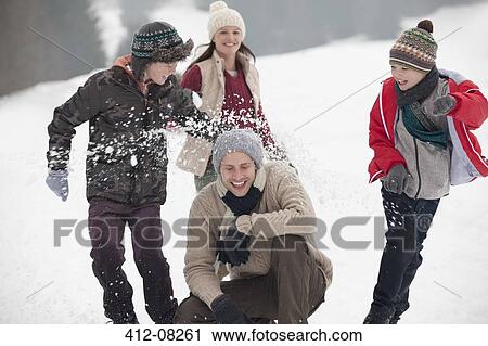 Playful family enjoying snowball fight in field View Large Photo Image Stock Image - Playful family enjoying snowball fight in field. Fotosearch