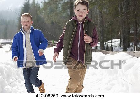 Portrait of happy boys running in snowy lane View Large Photo Image Stock Image - Portrait of happy boys running in snowy lane. Fotosearch