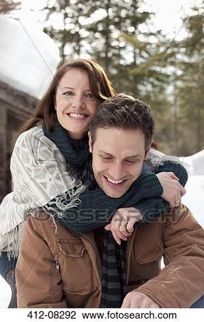 Portrait of hugging couple outside snowy cabin View Large Photo Image Stock Image - Portrait of hugging couple outside snowy cabin. Fotosearch
