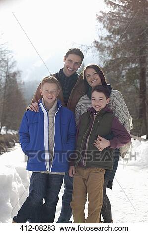 Stock Image - Portrait of smiling family in snowy lane. Fotosearch