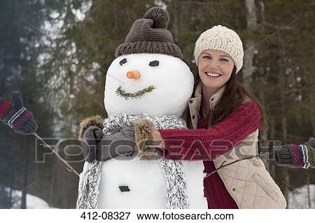 Portrait of smiling woman hugging snowman View Large Photo Image Stock Photo - Portrait of smiling woman hugging snowman. Fotosearch