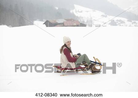 Portrait of smiling woman sledding in snowy field View Large Photo Image Stock Image - Portrait of smiling woman sledding in snowy field. Fotosearch