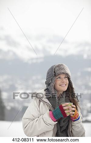 Smiling woman drinking coffee in snowy field View Large Photo Image Stock Image - Smiling woman drinking coffee in snowy field. Fotosearch