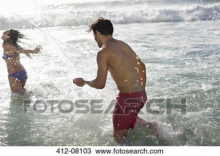 Couple splashing in ocean View Large Photo Image Stock Image - Couple splashing in ocean. Fotosearch