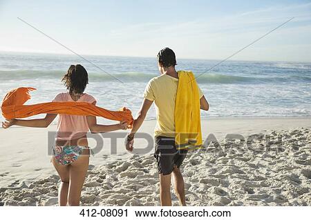 Couple walking on beach View Large Photo Image Stock Image - Couple walking on beach. Fotosearch