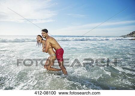 Enthusiastic couple hugging and splashing in ocean View Large Photo Image Stock Image - Enthusiastic couple hugging and splashing in ocean. Fotosearch