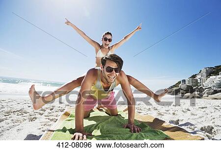Enthusiastic couple piggybacking on beach View Large Photo Image Stock Photograph - Enthusiastic couple piggybacking on beach. Fotosearch