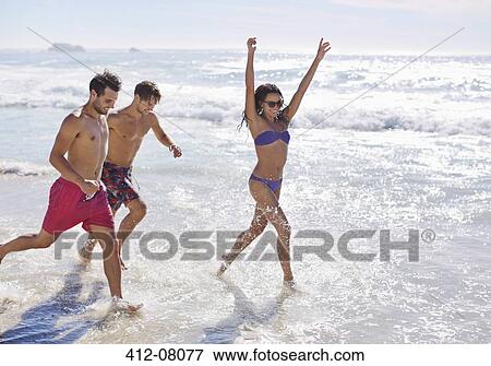 Enthusiastic friends running and splashing in ocean View Large Photo Image Stock Photo - Enthusiastic friends running and splashing in ocean. Fotosearch