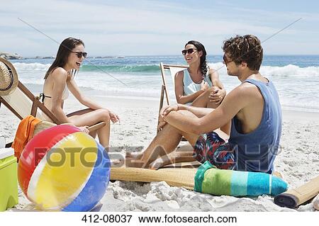 Friends hanging out at beach View Large Photo Image Stock Photo - Friends hanging out at beach. Fotosearch