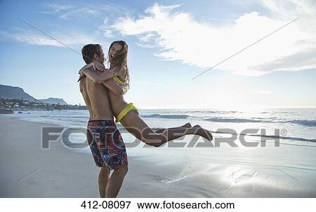 Happy couple hugging and spinning on beach View Large Photo Image Stock Photo - Happy couple hugging and spinning on beach. Fotosearch