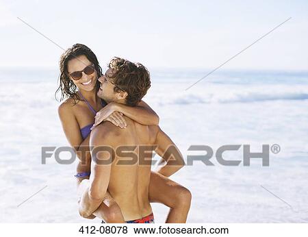 Happy couple hugging on beach View Large Photo Image Stock Photo - Happy couple hugging on beach. Fotosearch