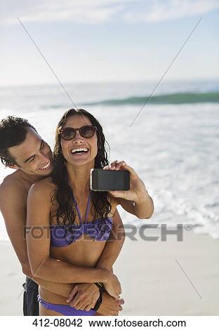 Happy couple taking self-portrait with camera phone on beach View Large Photo Image Stock Image - Happy couple taking self-portrait with camera phone on beach. Fotosearch