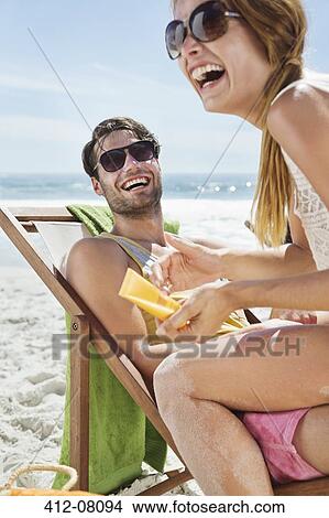 Happy couple with sunscreen at beach View Large Photo Image Picture - Happy couple with sunscreen at beach. Fotosearch