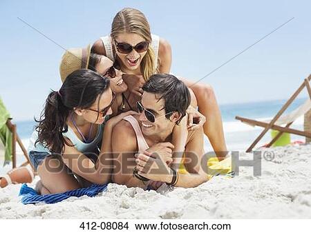 Happy friends laying on top of each other on beach View Large Photo Image Picture - Happy friends laying on top of each other on beach. Fotosearch