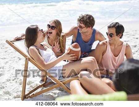 Happy friends with football hanging out at beach View Large Photo Image Picture - Happy friends with football hanging out at beach. Fotosearch