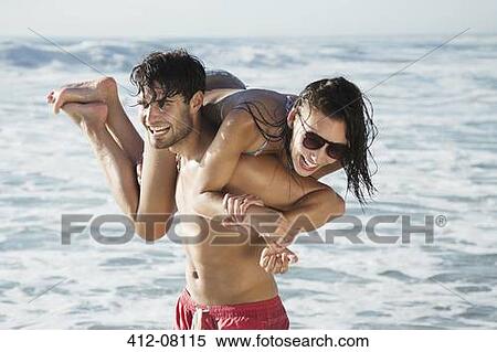 Happy man carrying woman on beach View Large Photo Image Stock Photography - Happy man carrying woman on beach. Fotosearch