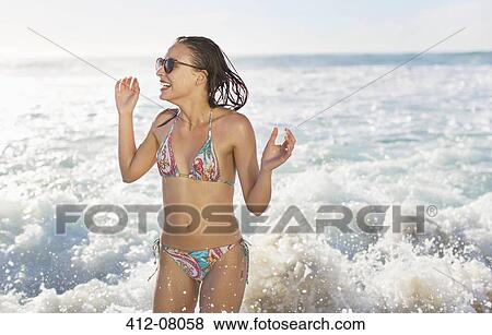 Happy woman in bikini splashing in ocean View Large Photo Image Stock Photo - Happy woman in bikini splashing in ocean. Fotosearch