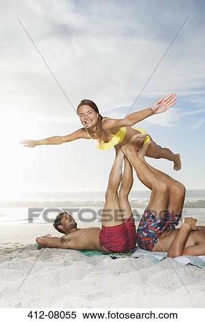 Men lifting woman with legs on beach View Large Photo Image Stock Photography - Men lifting woman with legs on beach. Fotosearch